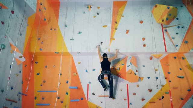 Man climbs on a wall fast.