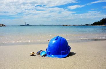 Obraz premium Safety Helmet and the sun glasses on the seascape background