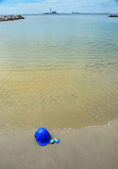 Safety Helmet and the sun glasses on the seascape background