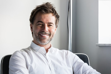 Handsome smiling man relaxing  in a sofa at the hotel