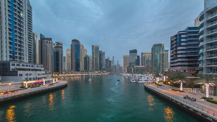 Naklejka premium View of Dubai Marina Towers and canal in Dubai day to night timelapse