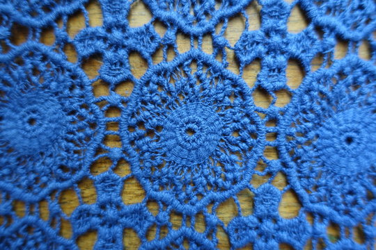 Classic blue lacy fabric on wood from above