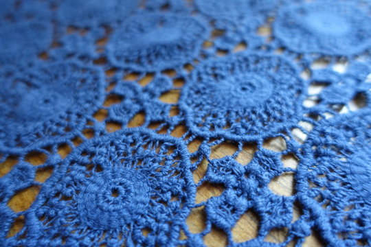 Close view of blue lacy fabric on wood
