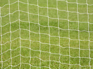 Soccer Goal Net with Green Grass Background with selective focus and crop fragment