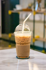 Iced coffee put whipped cream in a glass on the table.
