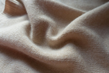 Simple beige knitted fabric in soft folds