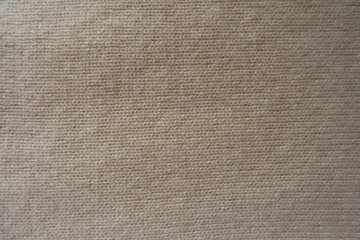 Fototapeta na wymiar Cream colored handmade knitted fabric from above