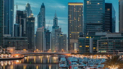 View of Dubai Marina Towers and canal in Dubai night to day timelapse