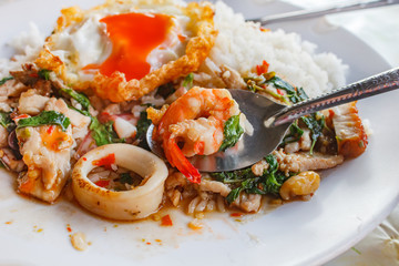 Rice topped with stir-fried all mixed and basil with fried egg.