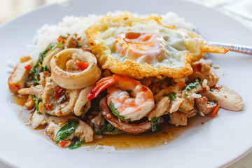 Rice topped with stir-fried all mixed and basil with fried egg.