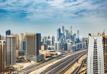 Fototapeta na wymiar Aerial daytime skyline of Dubai Marina, UAE, with skyscrapers in the distance. Scenic travel background.