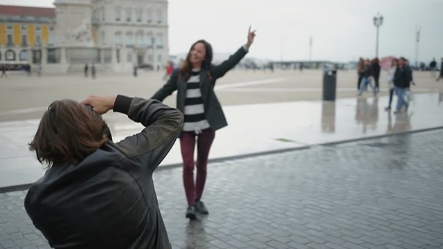 Male photographer taking pictures of laughing woman outdoor.