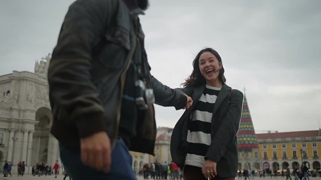 Happy young torists dancing on street.