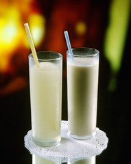 Dos vasos, uno con horchata de chufa y el otro con granizado de limonada.