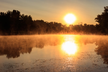 View of river in the mist at sunrise. Fog over river at morning