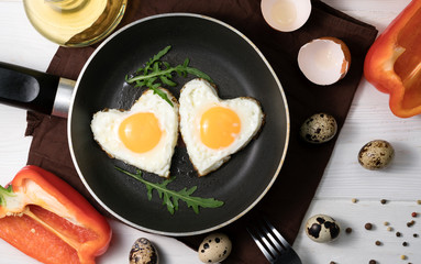 fried eggs in the shape of a heart in a pan