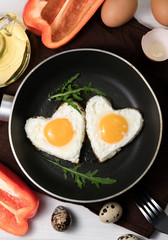 .fried eggs in the shape of a heart in a pan