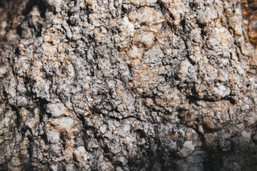 Close-up grungy rock textured with tiny glitter and shiny sharp pieces on the surface detail. Natural abstract background.