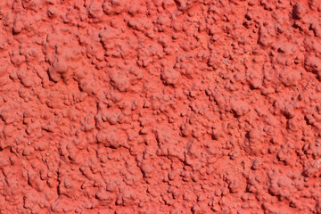 Facade wall red stucco plaster surface texture close up