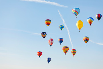 Multi colored hot air balloons flying over blue sky