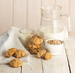 Oatmeal cookies with milk on tray on rustic wooden table