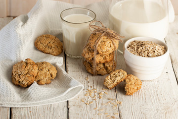 Oatmeal cookies with milk on tray on rustic wooden table