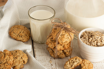 Oatmeal cookies with milk on tray on rustic wooden table
