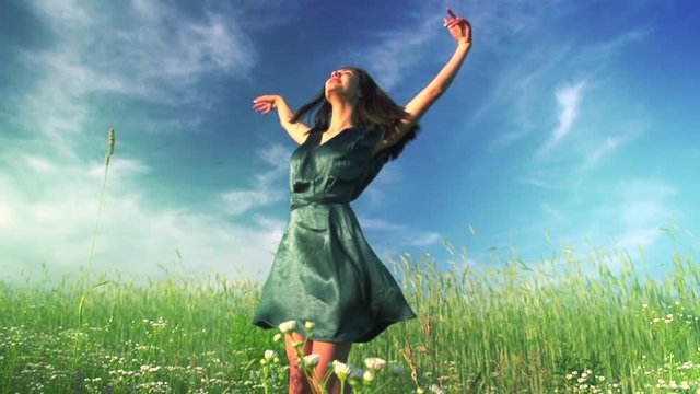 Beauty girl running and spinning on summer field, over sunset sky. Freedom concept. Happy young woman outdoors. Allergy free concept. Slow motion. 3840X2160 4K UHD video footage