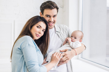Obraz premium portrait of young parents with baby at home