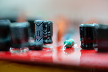 Close up (Macro) of Printed Circuit Board PCB embedded components (inductors, resistors, capacitors, diodes, microchips, transistor) with short depth of view