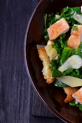 Salad with chicken, Parmesan cheese, crispy croutons and kale in a bowl
