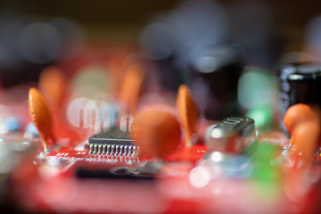 Close up (Macro) of Printed Circuit Board PCB embedded components (inductors, resistors, capacitors, diodes, microchips, transistor) with short depth of view