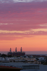 Obraz premium Sunrise over oil drilling rigs in port near dwelling, El Medano, Tenerife