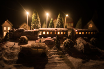 Fototapeta premium Miniature of winter scene with Christmas houses, train station, trees, covered in snow. Nights scene. New year or Christmas concept.
