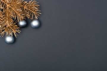 Creative decoration pattern with golden Christmas tree branches and silver baubles. Concept