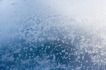 Winter blue background of snowflakes and frost. Crystals, the texture of the ice with the flare of the sun