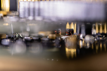 Close up (Macro) of Printed Circuit Board PCB embedded components (inductors, resistors, capacitors, diodes, microchips, transistor) with short depth of view.