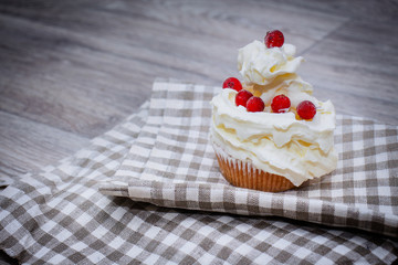 Close-up shot with whipped cream, fresh berries on a light checkered linen napkin.