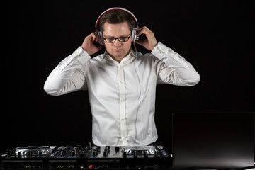 DJ hört konzentriert mehrere Tracks durch und bereitet seine Playlist vor