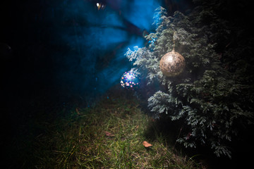 Obraz na płótnie Canvas Christmas and New Year decoration on the pine tree branch with lights at the background at night outdoors. Concept of winter holidays.
