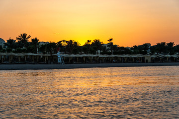 Fototapeta premium Sunset over the red sea palm tree silhuettes hotel in Makadi Bay Egypt