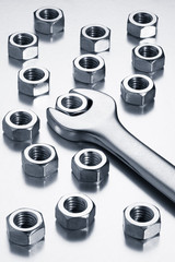 Metal nuts and wrench. Chrome vanadium tool on a white background.