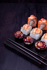 Sushi rolls assortment on a black board