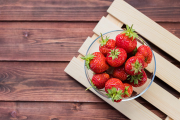 Heap of fresh strawberries in bowl on white wooden background. Concept of organic berry and nutrition. It is rich in antioxidant.Bowl of organic strawberries. freshly harvested fruits.Fresh summer