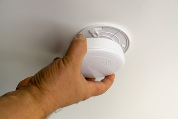 Man installing smoke or carbon monoxide detector