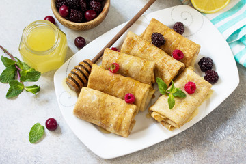 Healthy Pancakes breakfast. Stack of homemade thin pancakes or crepes whole grain flour, served with honey and fresh berries.
