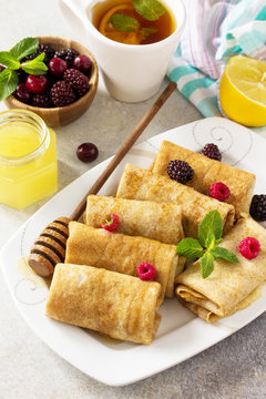 Healthy Pancakes breakfast. Stack of homemade thin pancakes or crepes whole grain flour, served with honey and fresh berries.