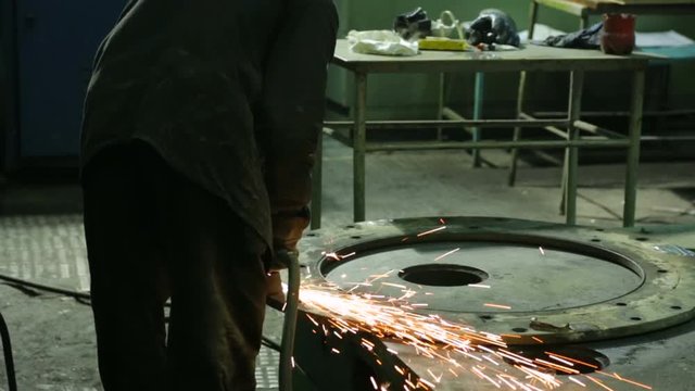 Worker at a factory working with a grinding machine
