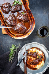 Traditionelle deutsche geschmorte Kalbsbäckchen in brauner Rotwein Sauce mit Kartoffelpüree als...