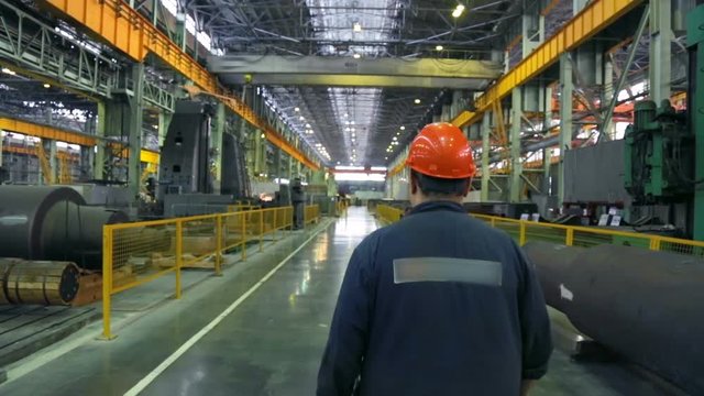 Worker walking along a walkway in a machine works